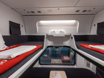 A new-generation Nightjet couchette compartment with a made-up berth on each side and the window between them.